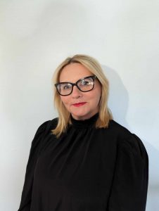 portrait image of Mandy in a black dress wearing glasses