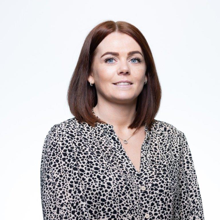 portrait image of Sara wearing a spotted black and white top with white background