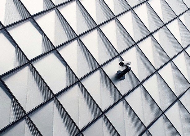 Image of security camera on the wall of a minimalist modernist building