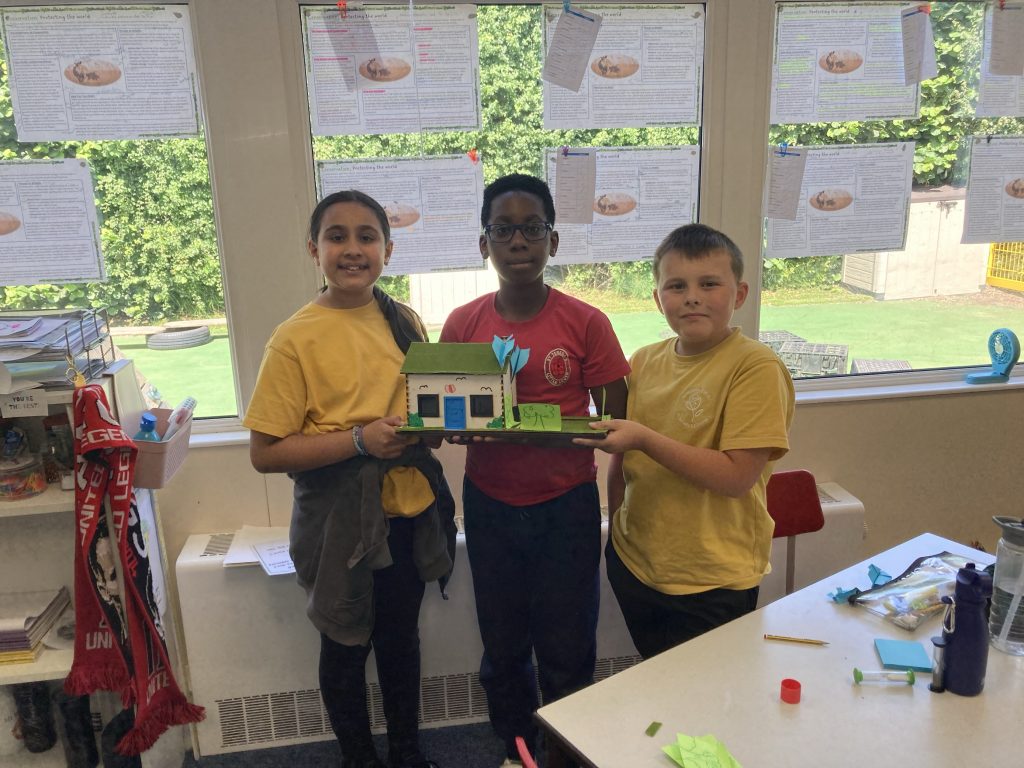 Primary school students showing their miniature greenhouse